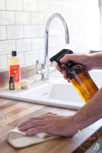 cleaning a counter with natural cleaning spray